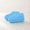 Blue silicone shoe covers with anti-slip soles on a marble surface