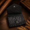 Tannor crocodile-embossed leather envelope wallet in black, open, showing the card slots