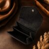 Tannor lizard-embossed leather envelope wallet in black, open, showing the card slots