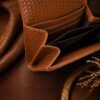 Tannor woven leather envelope wallet in chestnut brown, open, showing the note compartment and coin pocket