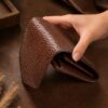 Tannor woven leather envelope wallet in dark chocolate, side profile showing the slim depth